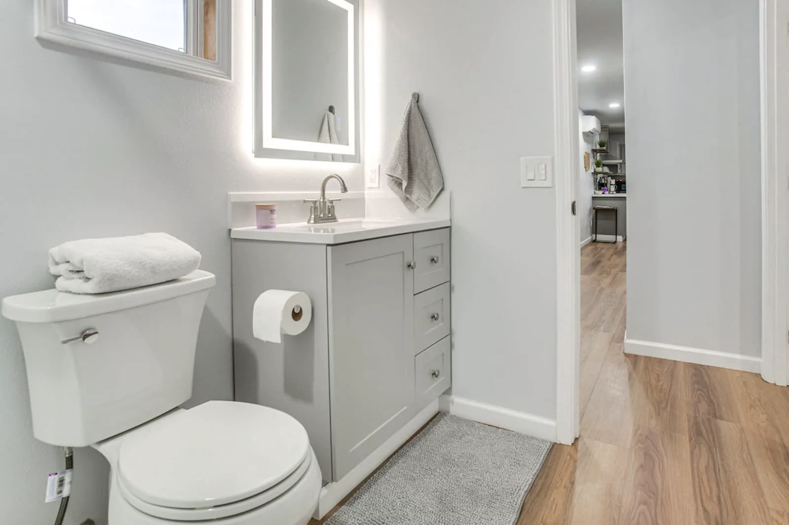 Remodeled bathroom — new vanity, lighted mirror, and fixtures